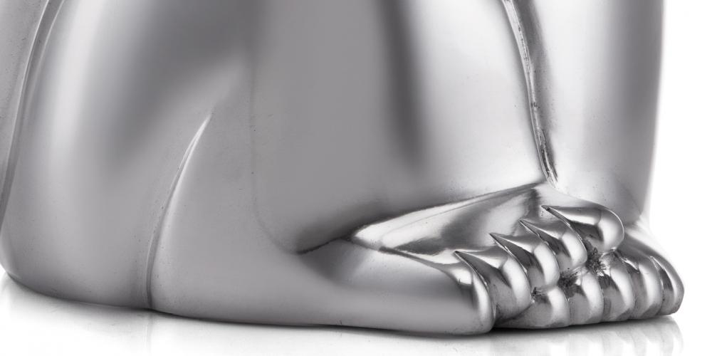 Close-up of a polished metallic statue's paw with detailed claws