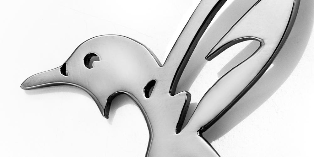 Stylized metallic hummingbird silhouette in polished finish