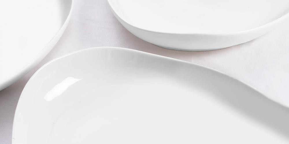 Set of three elegant white ceramic plates with smooth, curved edges.